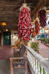 Dried chili peppers, called ristras, hanging  from wooden ceiling with intentionally blurred background and shallow depth of field.