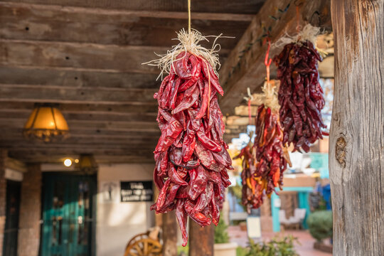 Dried chili peppers, called ristras, hanging  from wooden ceiling with intentionally blurred background and shallow depth of field.