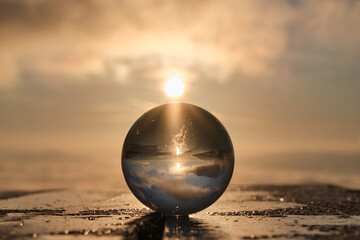 The landscape view on a nature through a glass ball with a sun in the background creative photography 