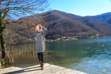 Beautiful young woman is standing by the lake