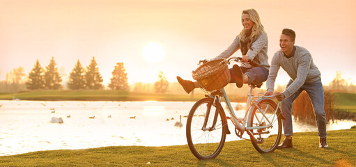 Happy young couple with bicycle having fun outdoors, space for text. Banner design