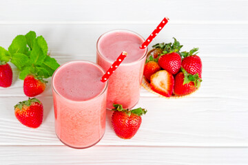 Strawberry yogurt fruit juice smoothie pink colorful fruit juice milkshake blend beverage healthy high protein the taste yummy In glass drink episode morning on white wood background.