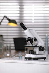 Modern medical microscope on white table in laboratory