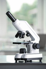 Modern medical microscope on metal table in laboratory
