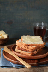 Tasty toasts with butter served on wooden table