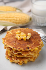Tasty corn pancakes on white plate, closeup