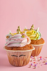 Cute sweet unicorn cupcakes on pink background