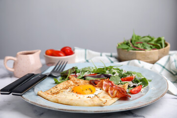 Delicious crepe with egg served on white marble table. Breton galette