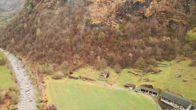 Fly Over The Maggia River Near Cevio Village With Autumnal Forest Mountains In Switzerland. Aerial Drone Shot