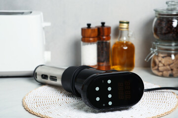 Thermal immersion circulator on table in kitchen, closeup. Sous vide cooking