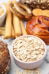 Different gluten free products on white marble table, closeup