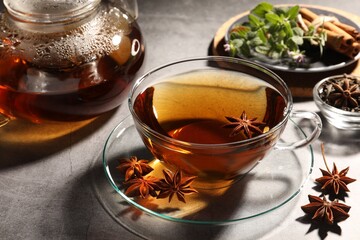 Aromatic tea with anise stars on light grey table