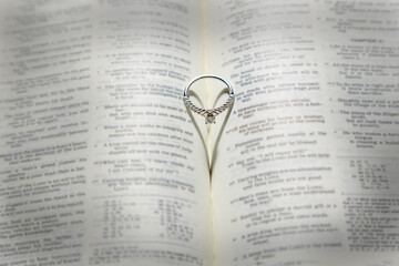 Wedding Rings with a heart shaped shadow on a Bible.
