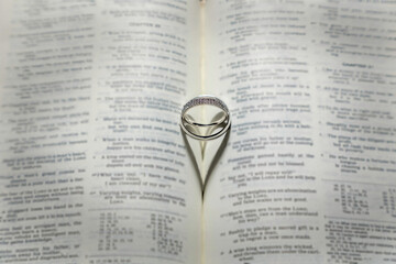 Wedding Rings with a heart shaped shadow on a Bible.