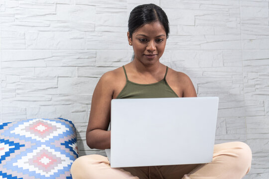 Woman In Her 30's Working On Her Laptop At Home Sitting On The Floor