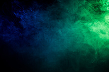 Fototapeta na wymiar Green-blue smoke in neon light on black background.