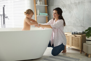 Mother with her little daughter in bathroom