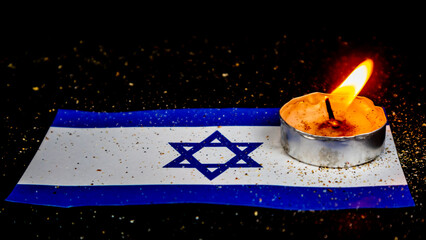 Israeli flag and candles burning above it, Holocaust memory day
