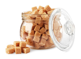 Glass jar and brown sugar cubes on white background
