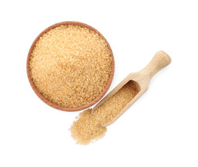 Wooden bowl and scoop of granulated brown sugar on white background, top view