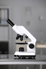 Modern medical microscope on metal table in laboratory