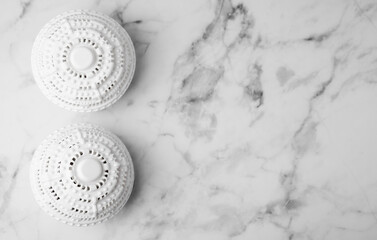 Laundry dryer balls on white marble table, flat lay. Space for text