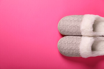 Pair of beautiful soft slippers on pink background, top view. Space for text