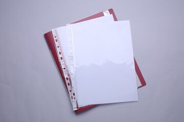 File folder with punched pockets and paper sheets on light grey background, top view