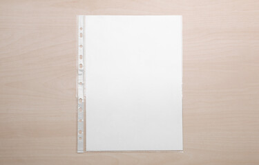 Punched pocket with paper sheet on wooden table, top view