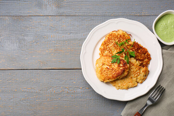 Tasty parsnip cutlets served on grey wooden table, flat lay. Space for text