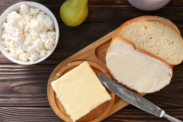 Tasty homemade butter, bread slices and tea on wooden table, flat lay