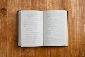Obraz premium Open old hardcover book on wooden table, top view