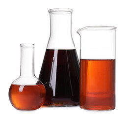 Different laboratory glassware with brown liquids on white background