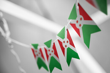Fototapeta premium A garland of Burundi national flags on an abstract blurred background
