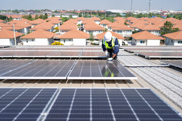 Engineer on rooftop kneeling next to solar panels photo voltaic with tool in hand for installation