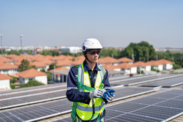Obraz premium Engineer on rooftop stand next to solar panels wear safety gear wear hand gloves ready to work