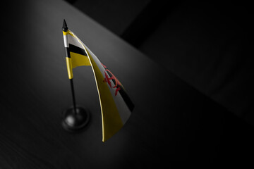 Small national flag of the Brunei on a black background