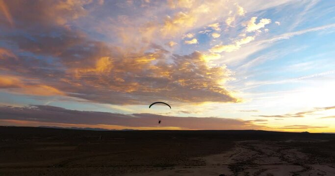 Stunning sunset with the silhouette of a powered paraglider in the Mojave Desert 