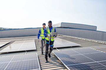 Engineer on rooftop stand next to solar panels discussion with team check laptop for installation