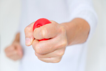 Hands of man with a gentle personality He exhibits stressful behavior from work, and he squeezes the yellow ball expressing emotion, anger, displeasure. Medical concepts and emotional regulation