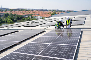 Engineer on rooftop kneeling next to solar panels photo voltaic with tool in hand for installation