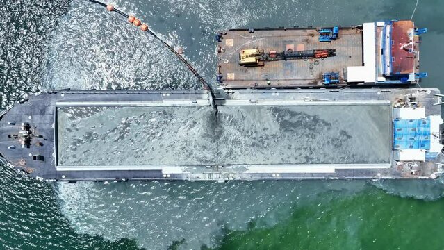 Dredging Vessel in action to keep waterways navigable, excavate and gathering sediments in the bottom and disposing at another location, Ship excavating material from a water environment