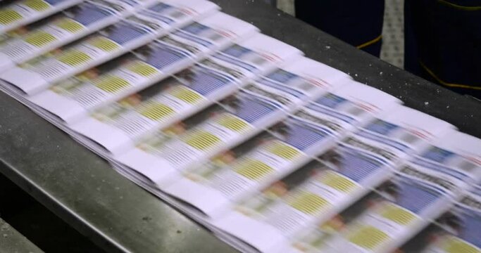stack of newspaper pages moving on a conveyor at a printing office. for news background