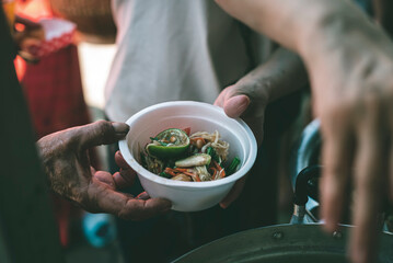 Concept of giving free food to the poor in the community : Volunteers handing out food to hungry people