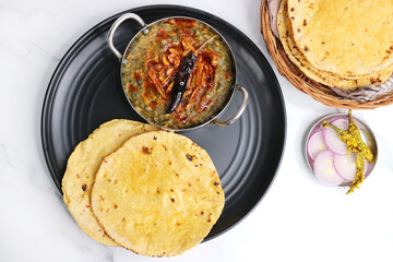 Sarson ka saag and Makke di roti. mustard leaves curry. It's a popular Punjabi winter dish made using corn meal and mustard leaves. served with onions and green chili. with copy space.