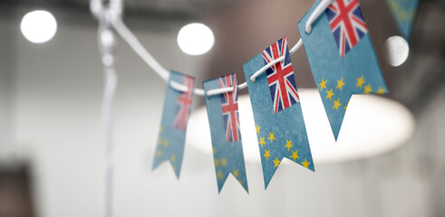 A garland of Tuvalu national flags on an abstract blurred background