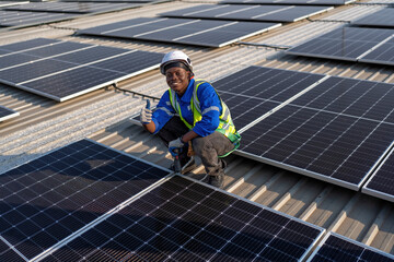 Engineer on rooftop sitting next to solar panels photo voltaic smiling portrait