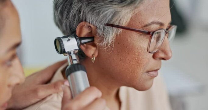 Nurse, ear or doctor consulting senior woman in an appointment checkup, hearing exam or testing audio results. Wellness, old woman or healthcare worker helping or checking tinnitus on elderly patient
