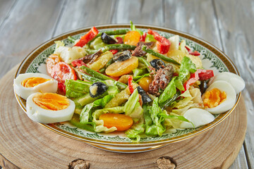 Nicoise salad french cuisine gourmet, on wooden background