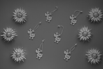 Snowflakes, flowers made of paper and funny wooden deer close-up view from above DIY on grey background. Children's paper crafts, New Year and Christmas decor, gift for holiday. Blurred background.
